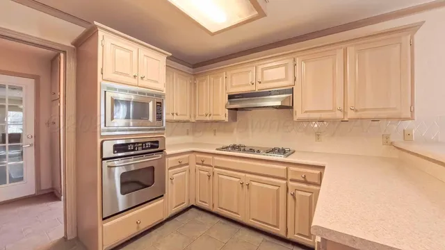 a kitchen with granite countertop a sink stove and cabinets