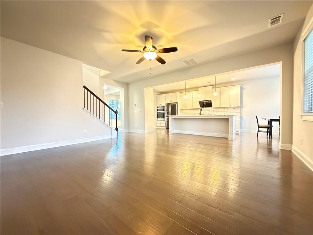 1545 Dahlia Drive Cumming, GA 30040 - Photo 14 of 50 a view of empty room with wooden floor and windows