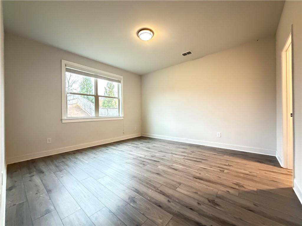 1545 Dahlia Drive Cumming, GA 30040 - Photo 22 of 50 an empty room with wooden floor and windows