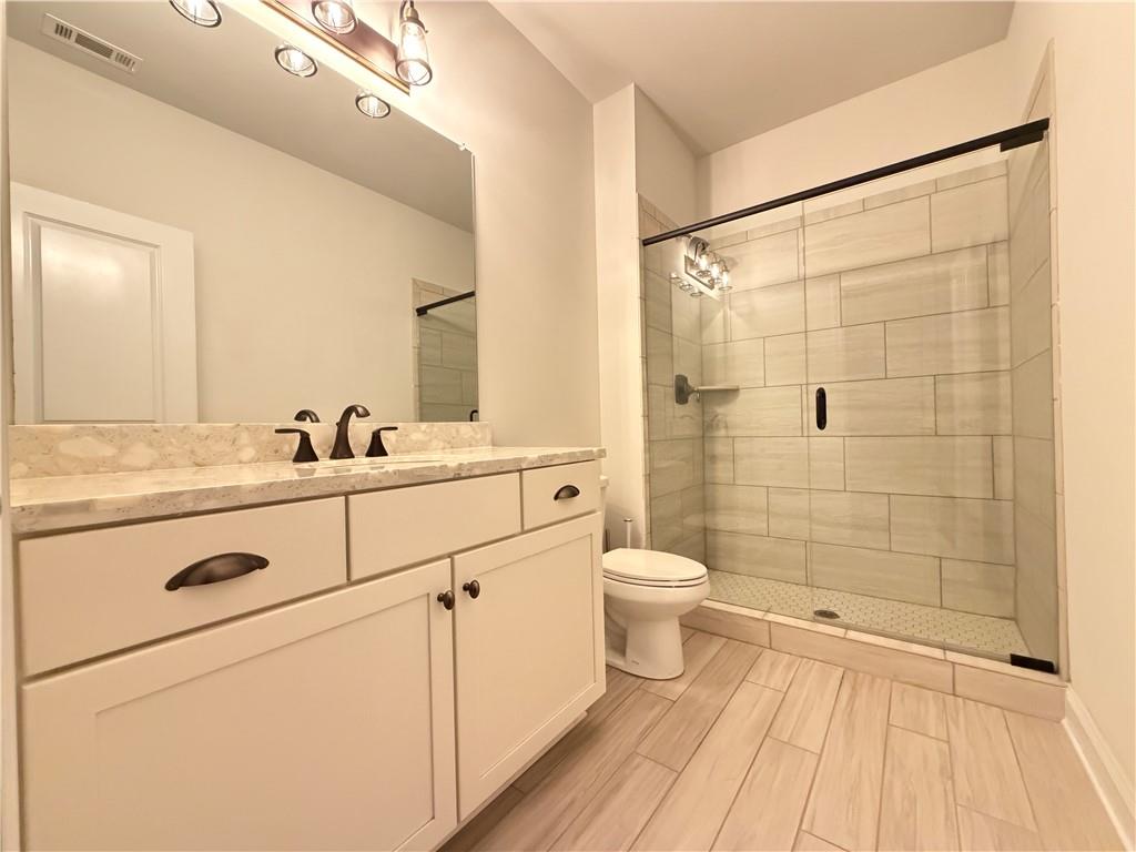 1545 Dahlia Drive Cumming, GA 30040 - Photo 24 of 50 a bathroom with a sink a toilet and shower