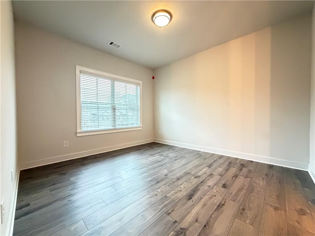 1545 Dahlia Drive Cumming, GA 30040 - Photo 41 of 50 an empty room with wooden floor and windows