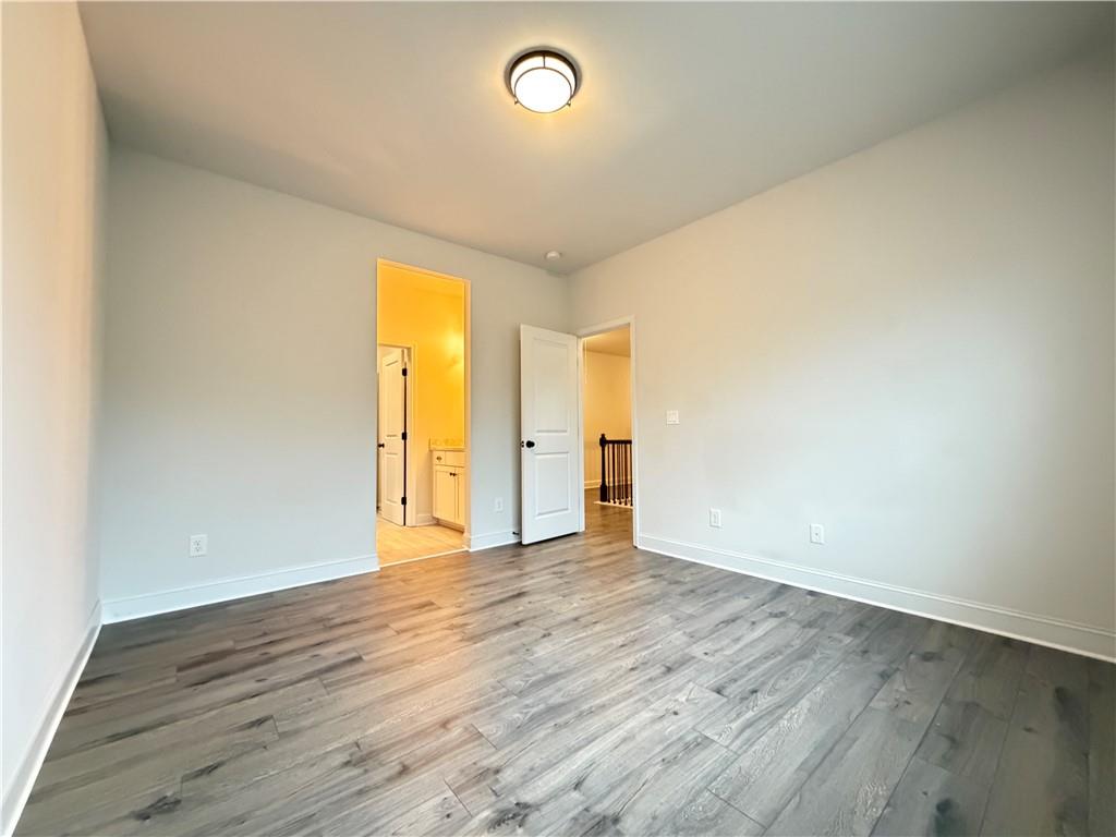 1545 Dahlia Drive Cumming, GA 30040 - Photo 42 of 50 an empty room with wooden floor and windows