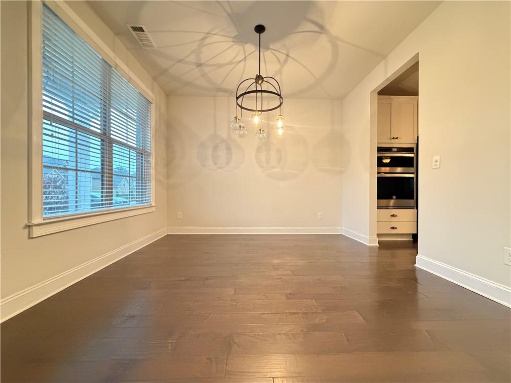1545 Dahlia Drive Cumming, GA 30040 - Photo 7 of 50 a view of a room with wooden floor and windows