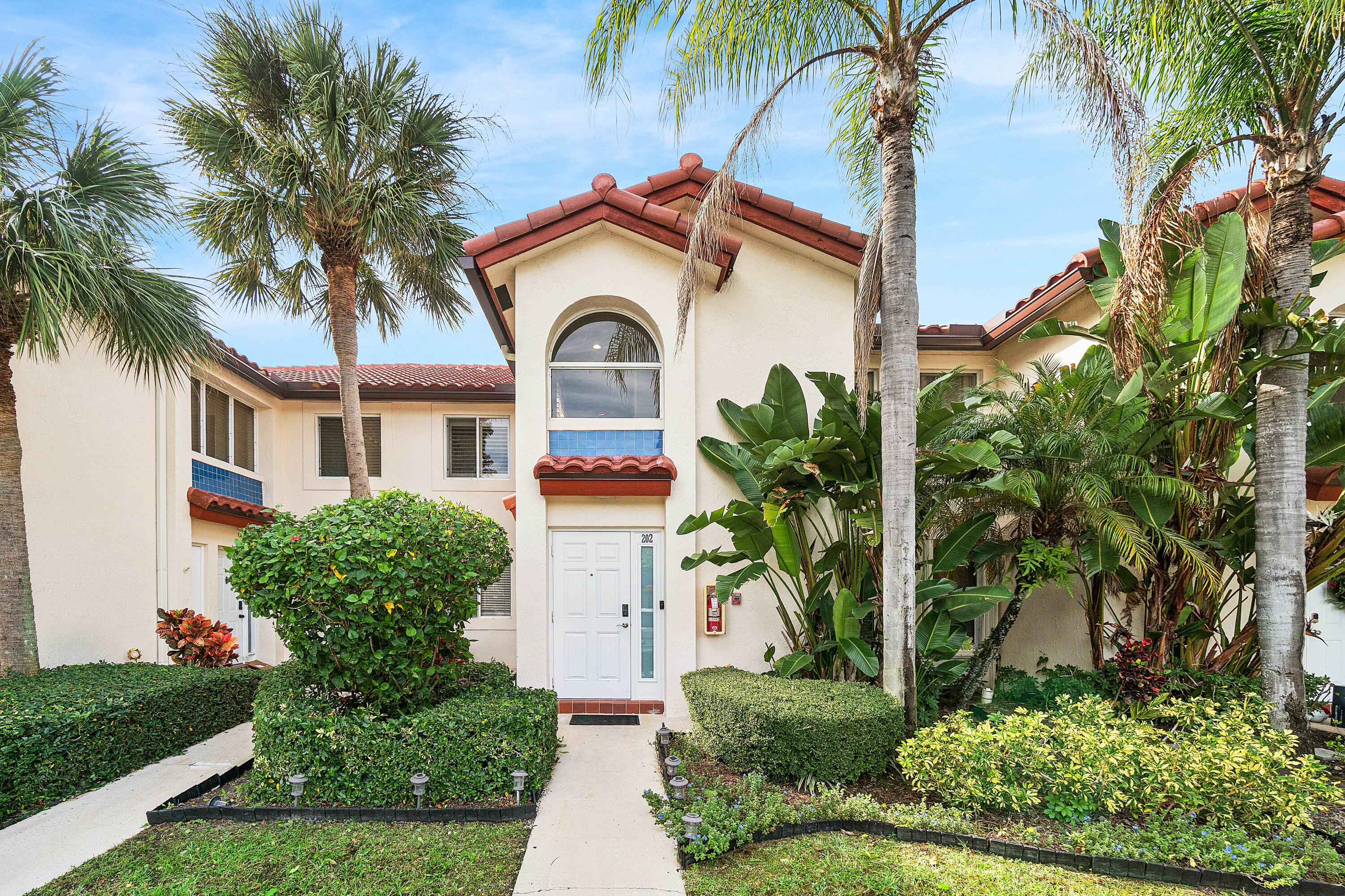 340 Northwest 67th Street, Unit 202 Boca Raton, FL 33487 - Photo 1 of 39 a front view of a house with a garden