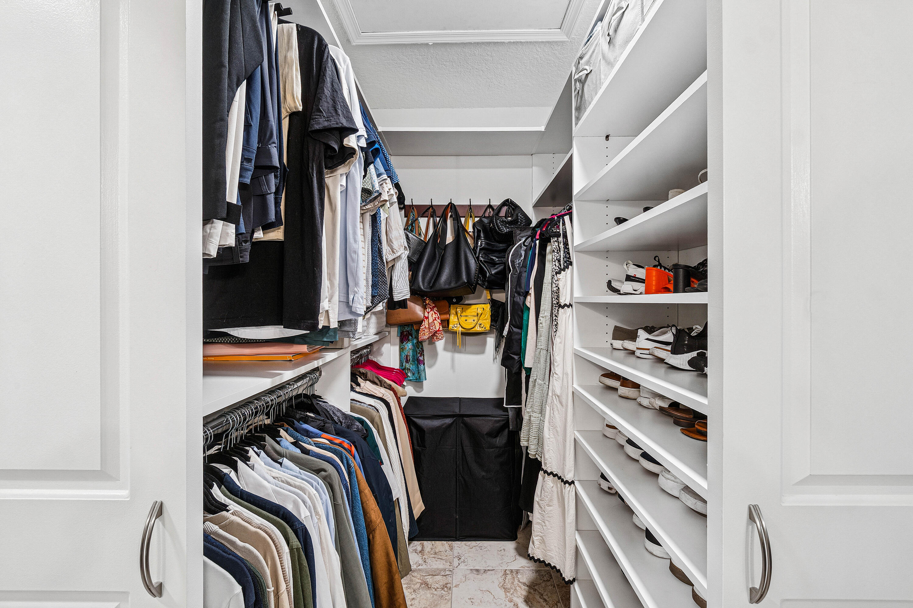 340 Northwest 67th Street, Unit 202 Boca Raton, FL 33487 - Photo 23 of 39 a view of walk in closet with clothes and shoes