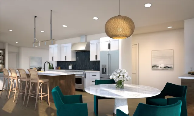 a kitchen with stainless steel appliances granite countertop a dining table chairs and a refrigerator