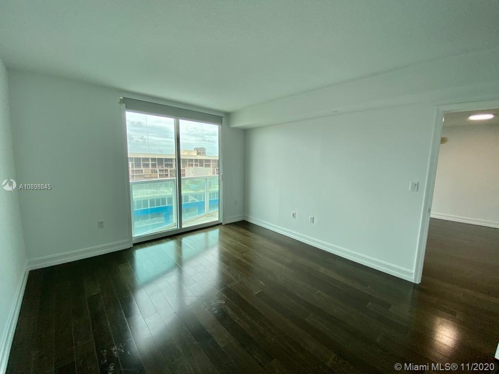 2101 Brickell Avenue, Unit 2002 Miami, FL 33129 - Photo 11 of 26 a view of an empty room with wooden floor and a window