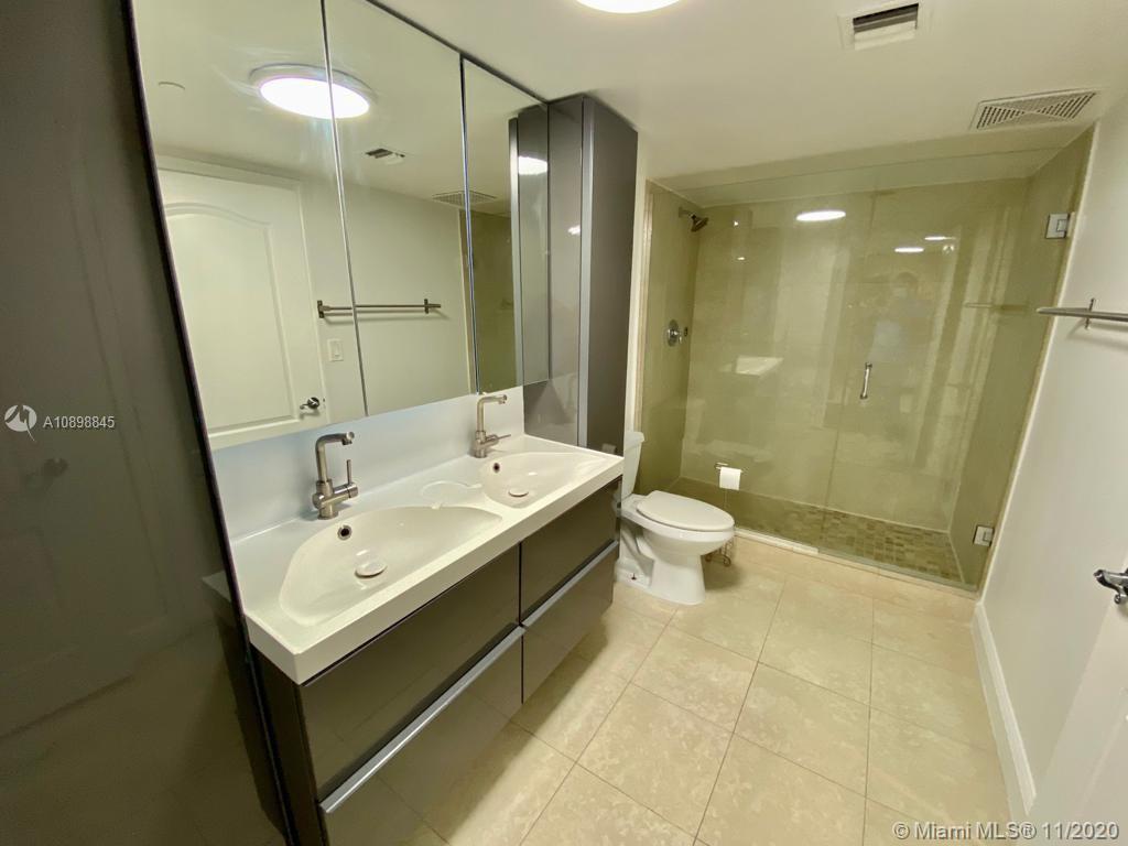2101 Brickell Avenue, Unit 2002 Miami, FL 33129 - Photo 12 of 26 a bathroom with a double vanity sink toilet and shower