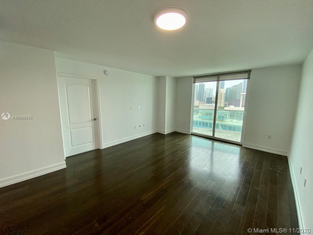 2101 Brickell Avenue, Unit 2002 Miami, FL 33129 - Photo 4 of 26 an empty room with wooden floor and windows