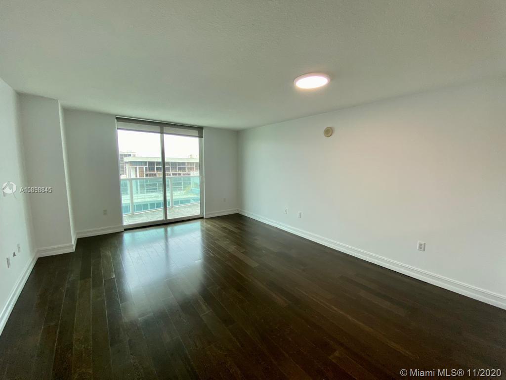 2101 Brickell Avenue, Unit 2002 Miami, FL 33129 - Photo 6 of 26 an empty room with wooden floor and windows