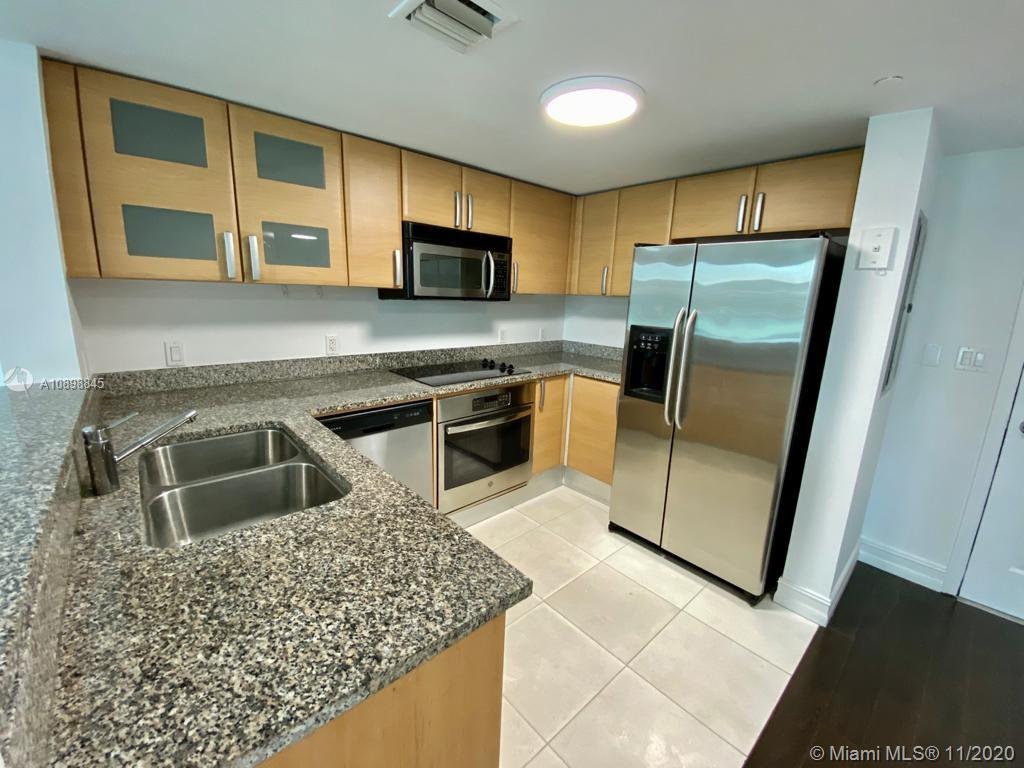 2101 Brickell Avenue, Unit 2002 Miami, FL 33129 - Photo 8 of 26 a kitchen with stainless steel appliances granite countertop a refrigerator a stove top oven a sink and dishwasher