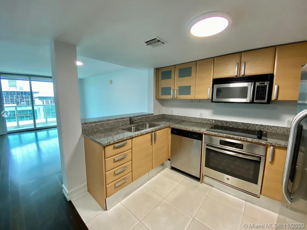 2101 Brickell Avenue, Unit 2002 Miami, FL 33129 - Photo 9 of 26 a kitchen with stainless steel appliances granite countertop a stove and a microwave