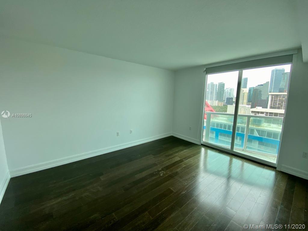 2101 Brickell Avenue, Unit 2002 Miami, FL 33129 - Photo 10 of 26 a view of an empty room with wooden floor and a window