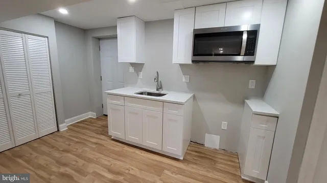 a kitchen with white cabinets stainless steel appliances and sink
