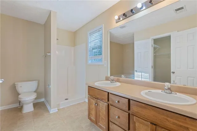 a bathroom with a double vanity sink and a toilet