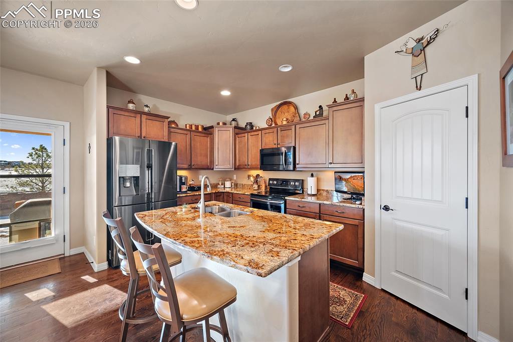 12988 Cupcake Heights Colorado Springs, CO 80921 - Photo 12 of 39 a open kitchen with a table chairs and refrigerator