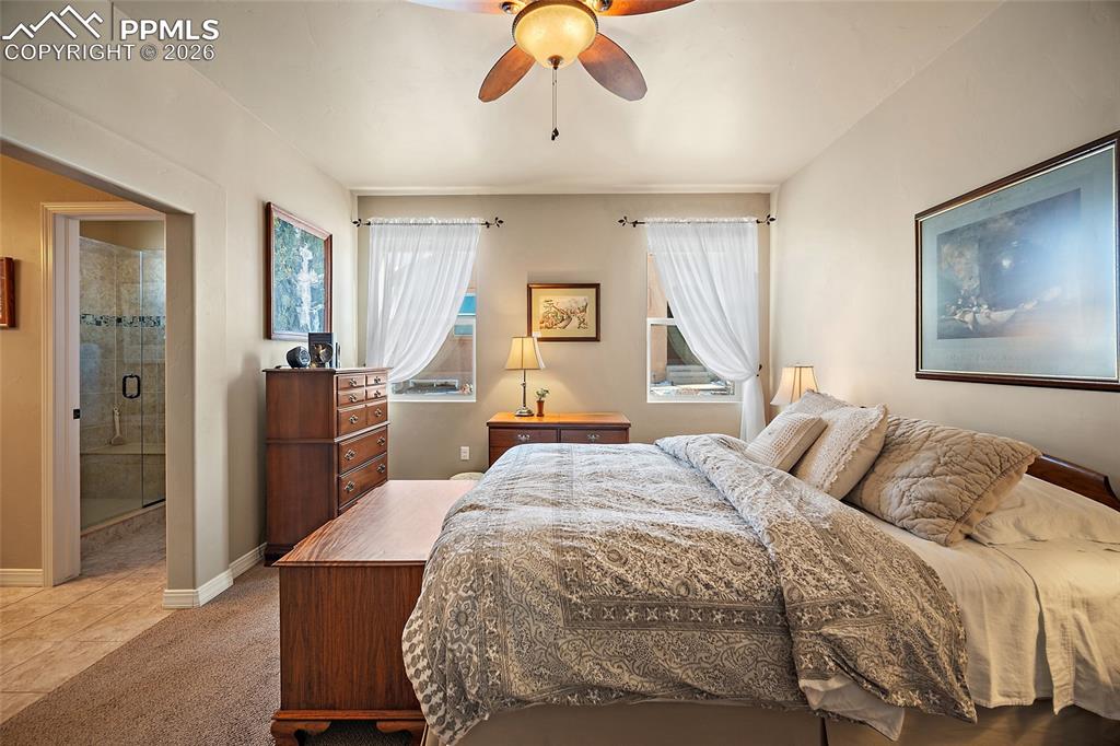 12988 Cupcake Heights Colorado Springs, CO 80921 - Photo 15 of 39 a bedroom with a bed and a chandelier