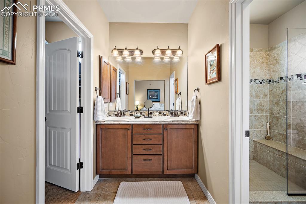 12988 Cupcake Heights Colorado Springs, CO 80921 - Photo 17 of 39 a bathroom with a double vanity sink mirror and shower