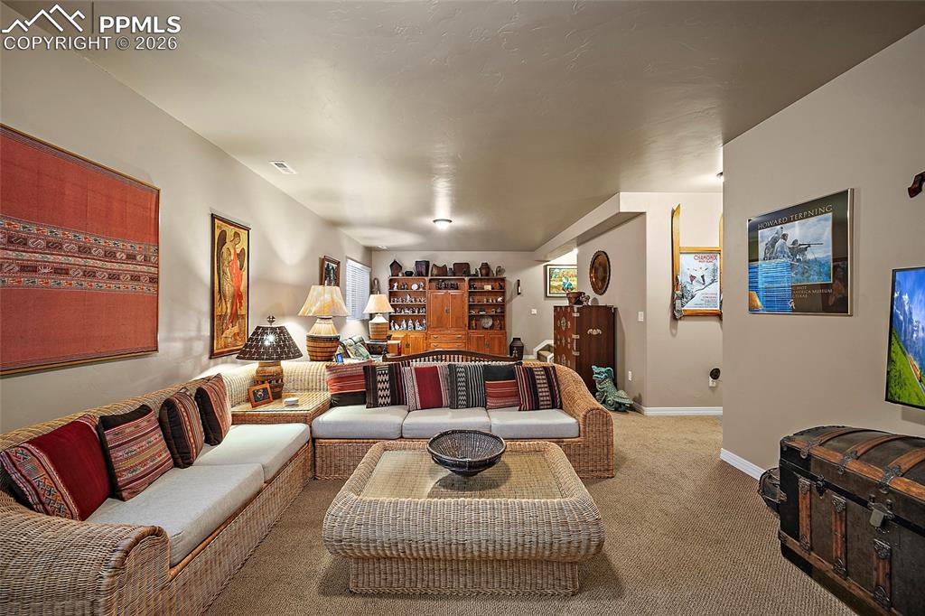 12988 Cupcake Heights Colorado Springs, CO 80921 - Photo 23 of 39 a living room with furniture and a flat screen tv