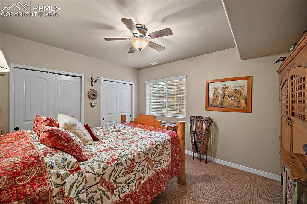 12988 Cupcake Heights Colorado Springs, CO 80921 - Photo 28 of 39 a bedroom with a bed and a chandelier