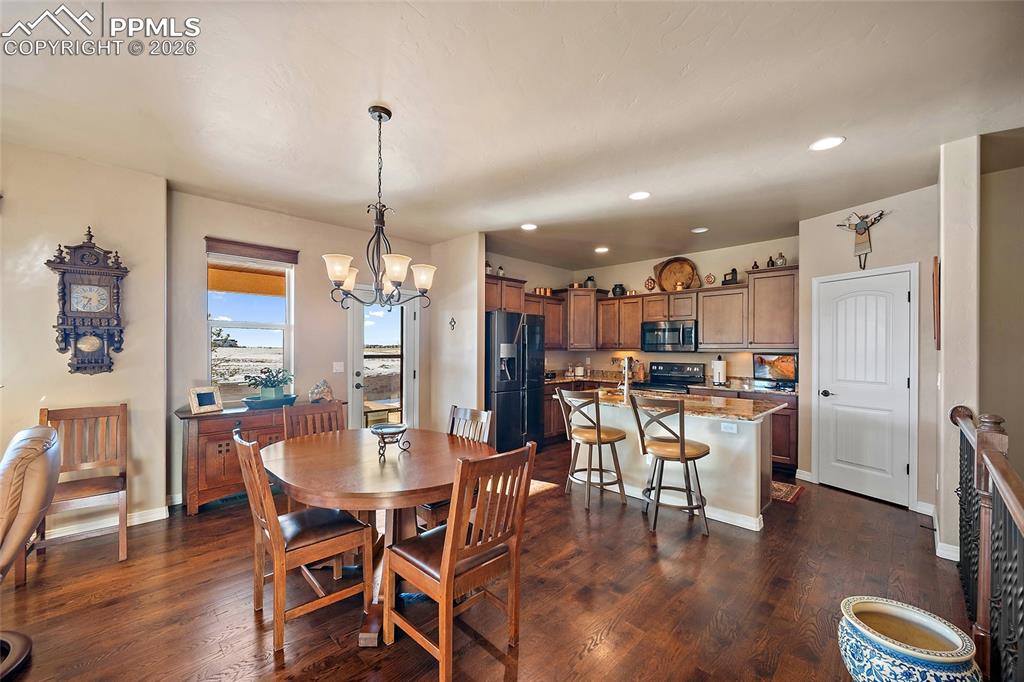 12988 Cupcake Heights Colorado Springs, CO 80921 - Photo 8 of 39 a dining room with furniture window and wooden floor