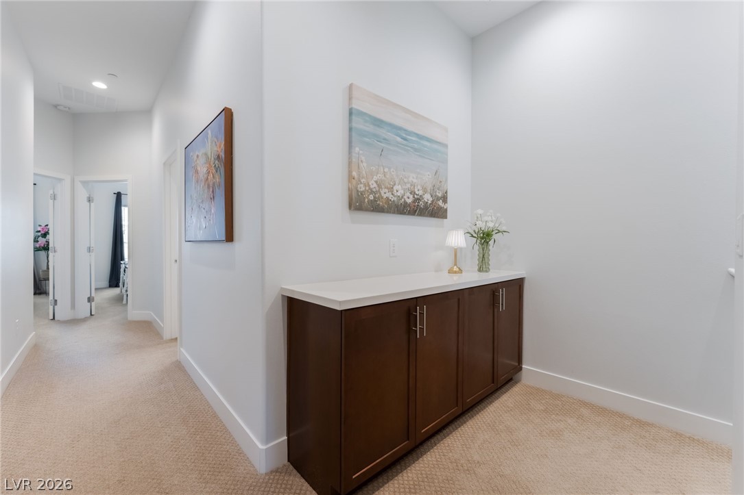 6432 Spring Jog Street Las Vegas, NV 89166 - Photo 17 of 61 A well-lit hallway with built-in cabinetry provides convenient storage.