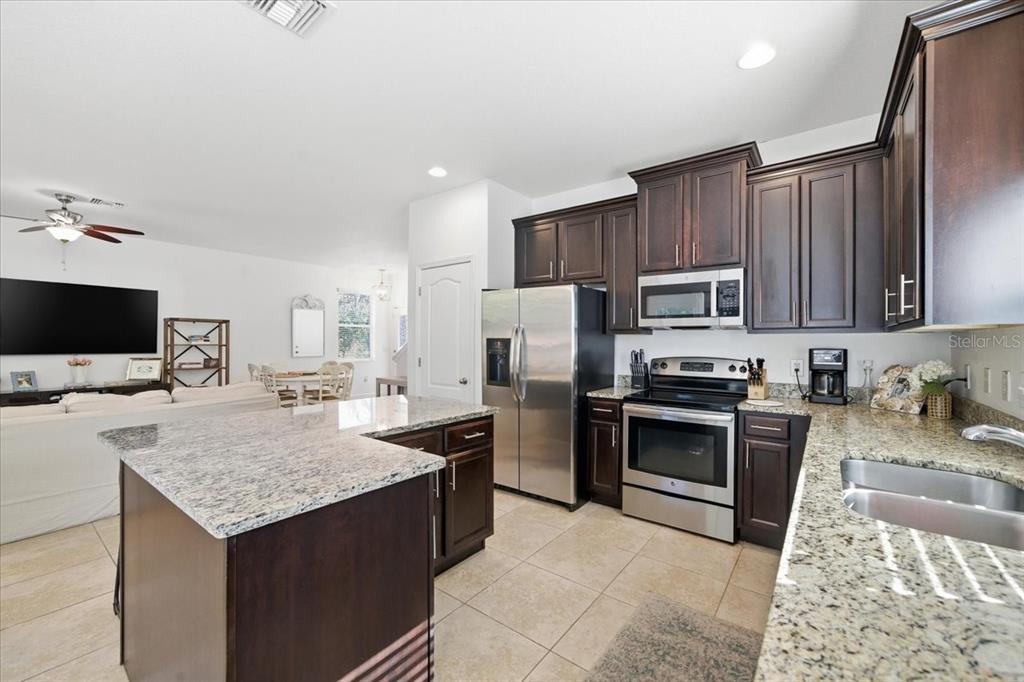 12330 North Rome Avenue Tampa, FL 33612 - Photo 10 of 33 a kitchen with granite countertop stainless steel appliances and wooden cabinets
