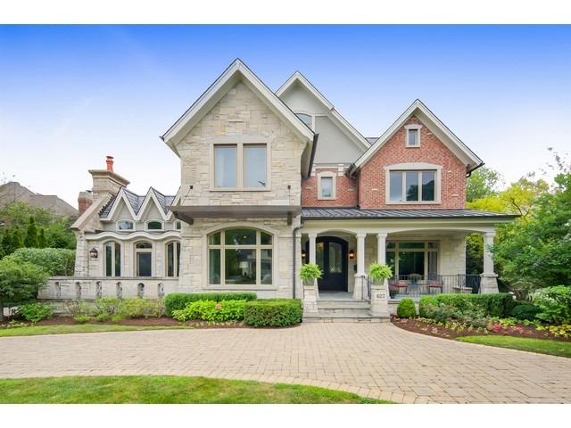 a front view of a house with a yard and potted plants