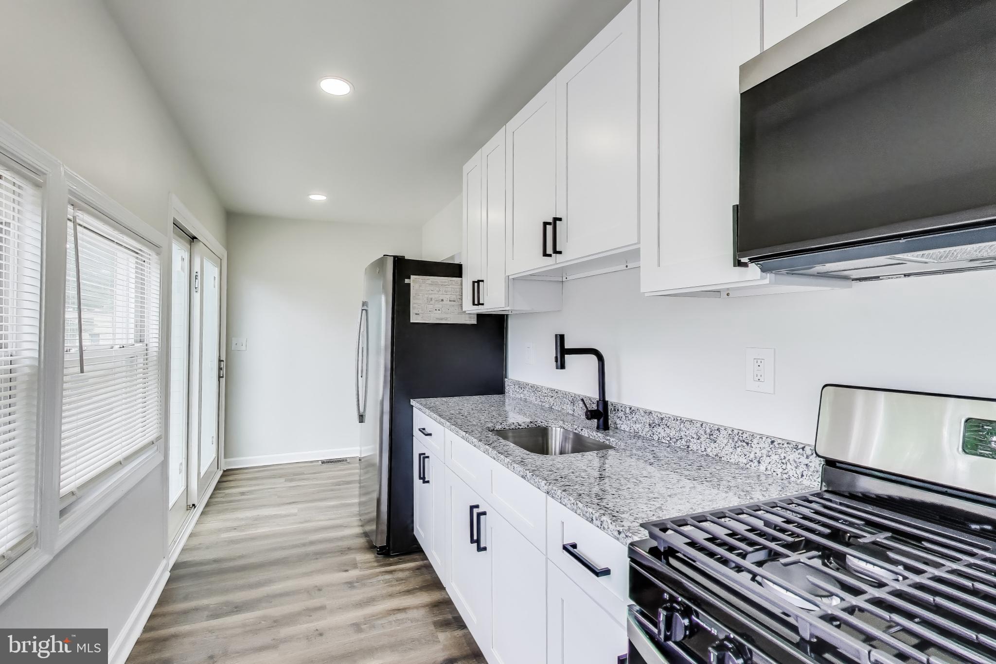1 Maple Avenue Baltimore, MD 21206 - Photo 11 of 53 a kitchen with stainless steel appliances granite countertop a sink and a stove