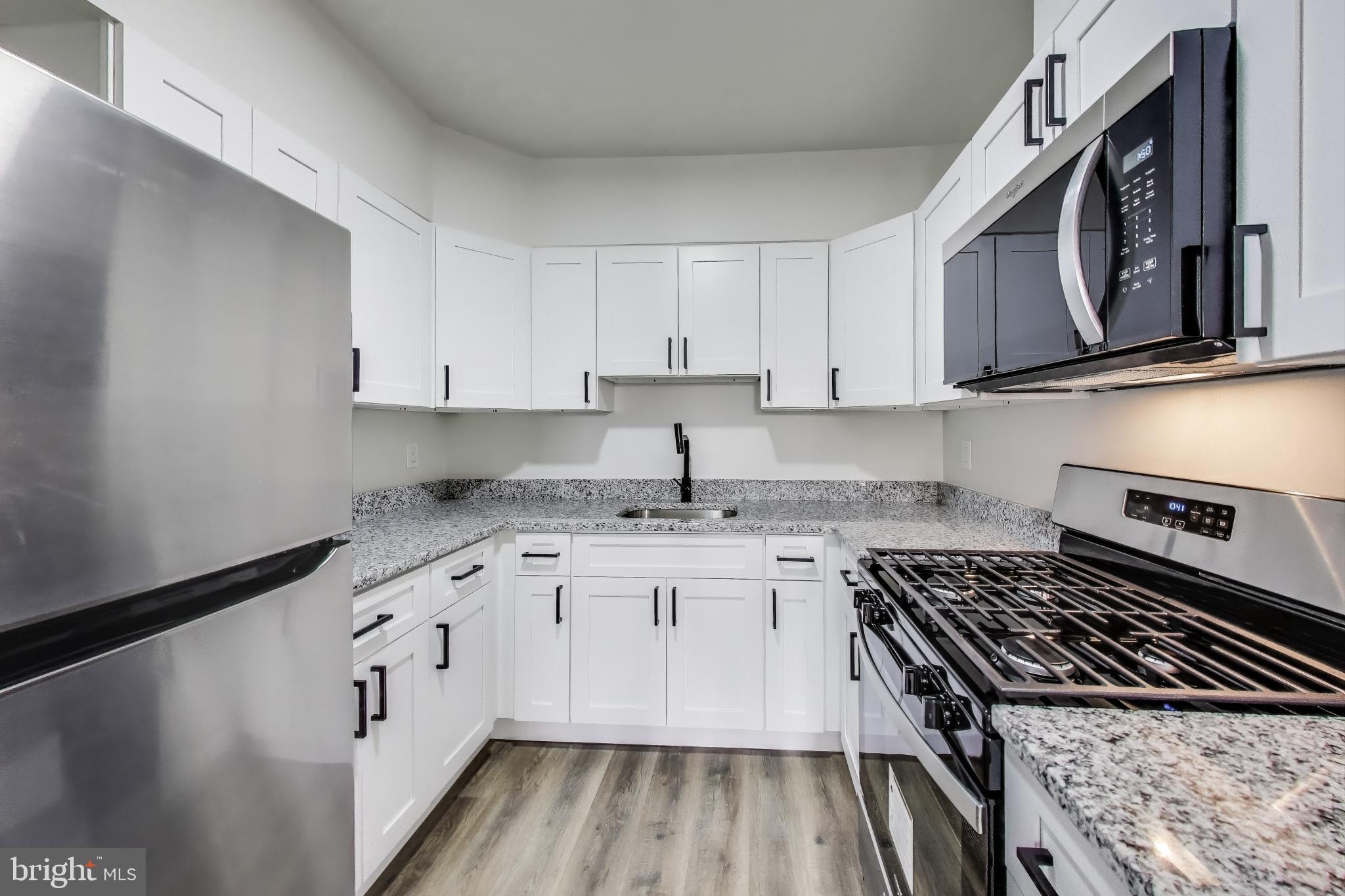 1 Maple Avenue Baltimore, MD 21206 - Photo 33 of 53 a kitchen with granite countertop a sink stove and cabinets
