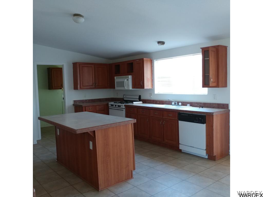 586 Bacobi Road Golden Valley, AZ 86413 - Photo 20 of 36 a kitchen with stainless steel appliances granite countertop a stove a sink and a microwave