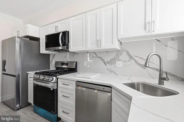 a kitchen with white cabinets and stainless steel appliances