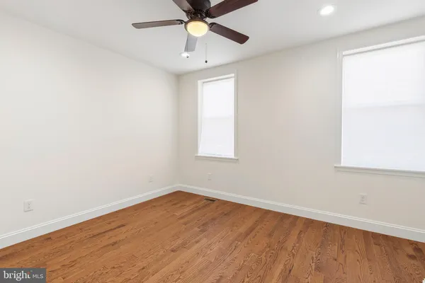 an empty room with a window and a ceiling fan