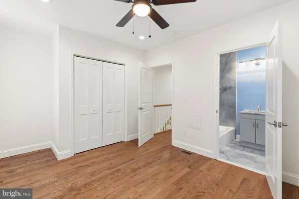 a view of a livingroom with wooden floor and a bathroom