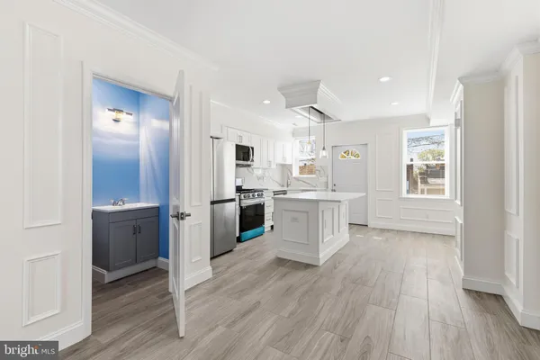 a large kitchen with a wooden floor and white cabinets