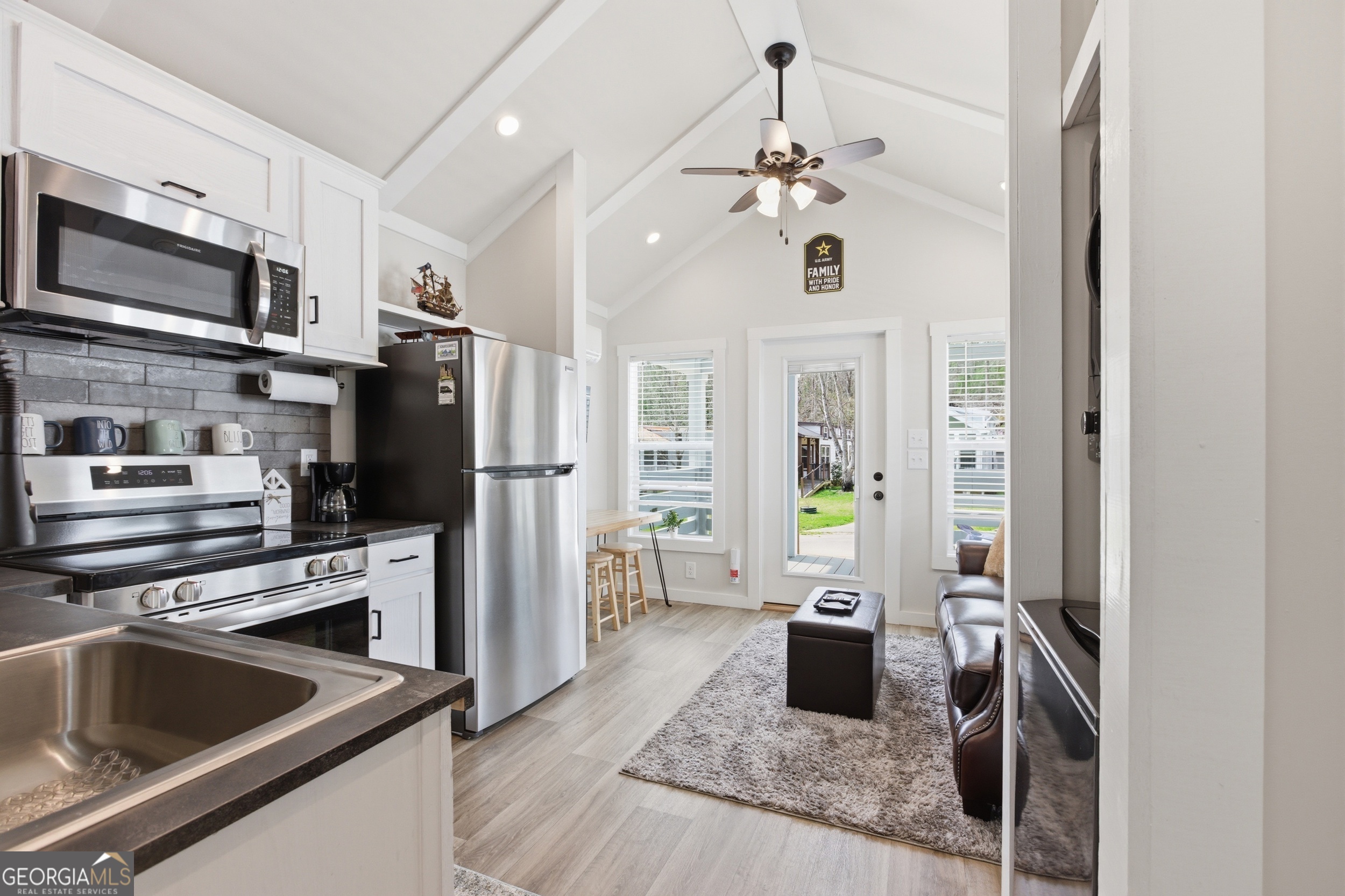 4960 Laurel Lodge Road, Unit 40 Clarkesville, GA 30523 - Photo 16 of 33 a kitchen with stainless steel appliances granite countertop a refrigerator oven a sink dishwasher and white cabinets with wooden floor