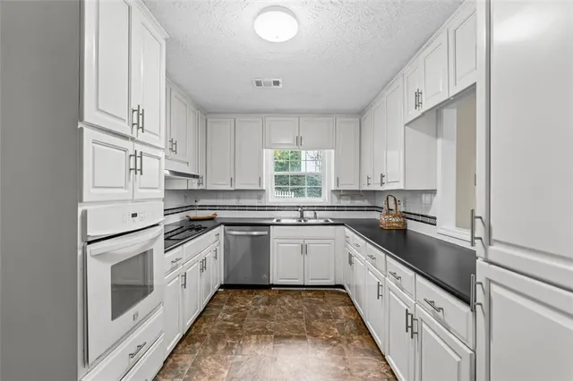 a kitchen with white cabinets and white appliances