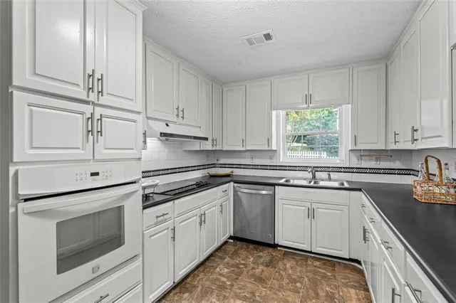 a kitchen with stainless steel appliances granite countertop white cabinets and a granite counter tops