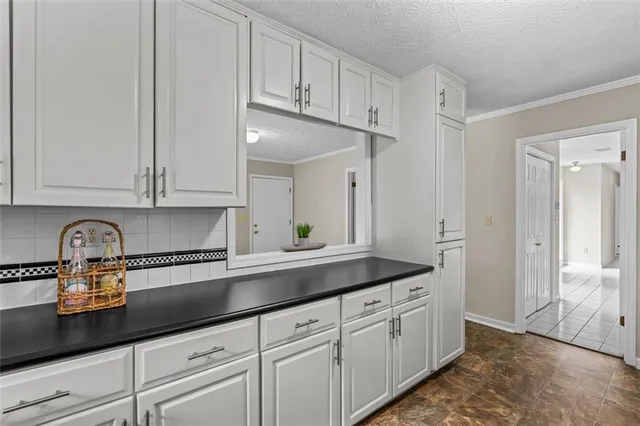 a close view of a stove a sink and dishwasher with white cabinets