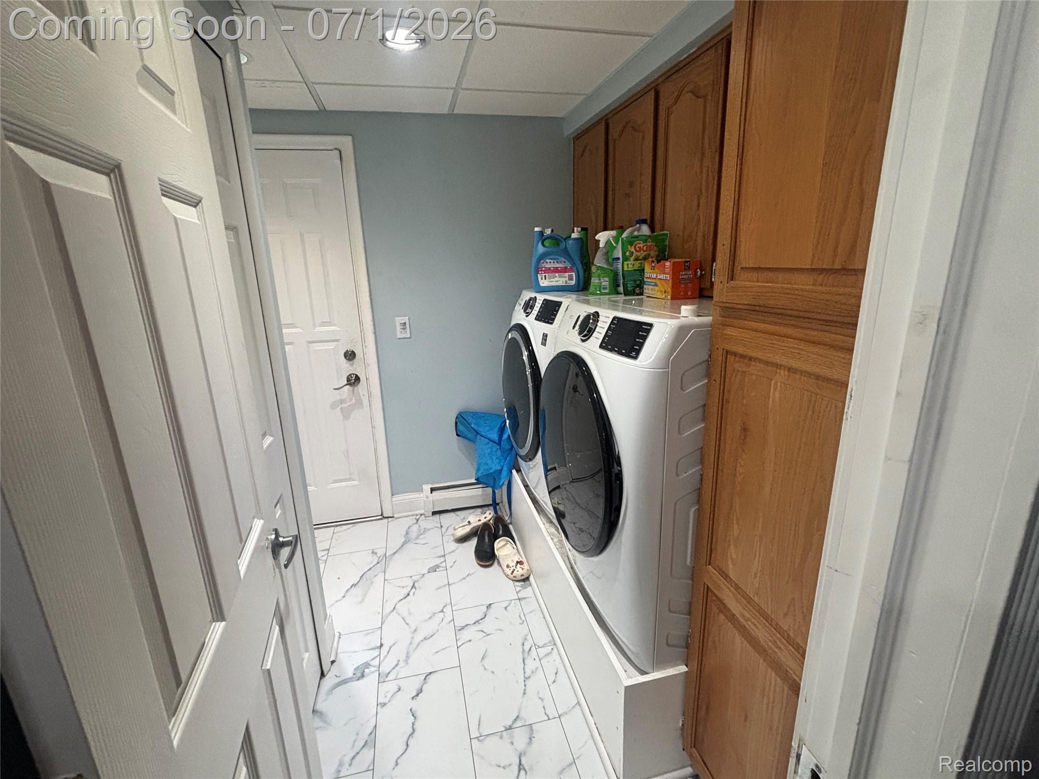9844 Pine Knob Road Clarkston, MI 48348 - Photo 13 of 15 Laundry area featuring floor-to-ceiling wood cabinetry, white-finish washer and dryer, recessed lighting, and white marble-look tile flooring