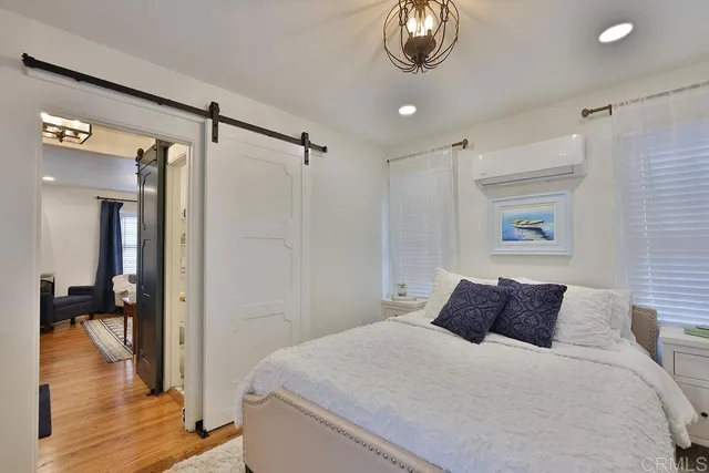 a bedroom with a large bed and a chandelier