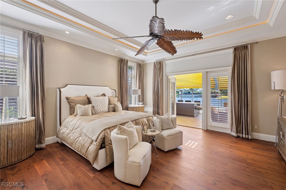 361 Pirates Bight Naples, FL 34103 - Photo 15 of 33 a bedroom with a large bed chandelier and a window