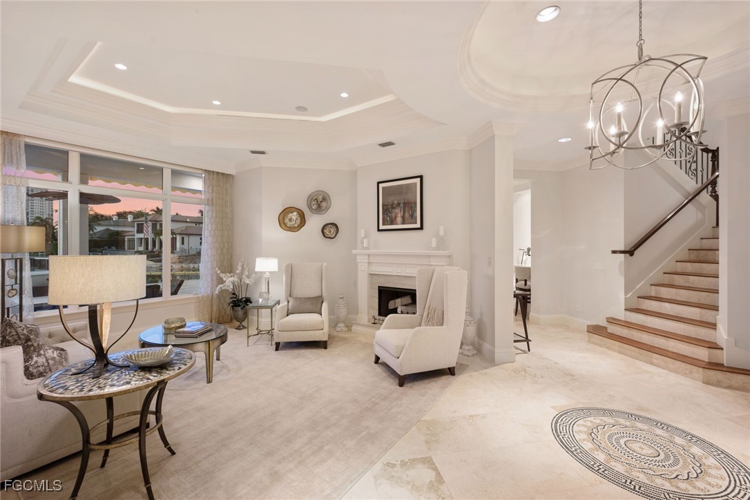 361 Pirates Bight Naples, FL 34103 - Photo 24 of 33 a living room with furniture a fireplace and a chandelier