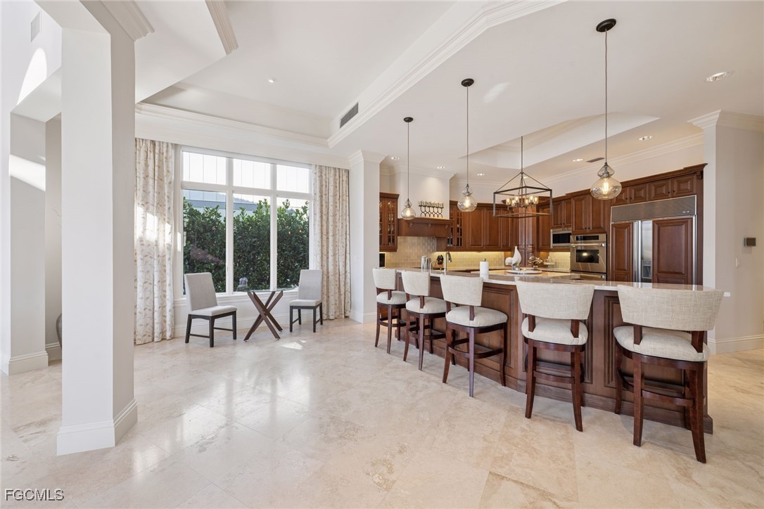 361 Pirates Bight Naples, FL 34103 - Photo 3 of 33 a room with lots of wooden furniture a large window and stainless steel appliances