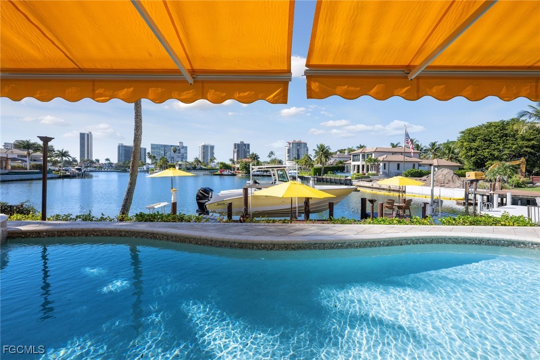 361 Pirates Bight Naples, FL 34103 - Photo 8 of 33 a view of a swimming pool with a table and chairs under an umbrella