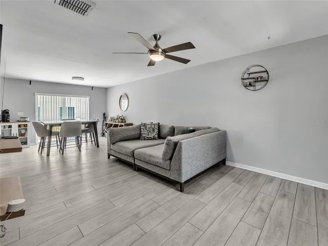 a dining hall with stainless steel appliances granite countertop a table chairs sink and cabinets