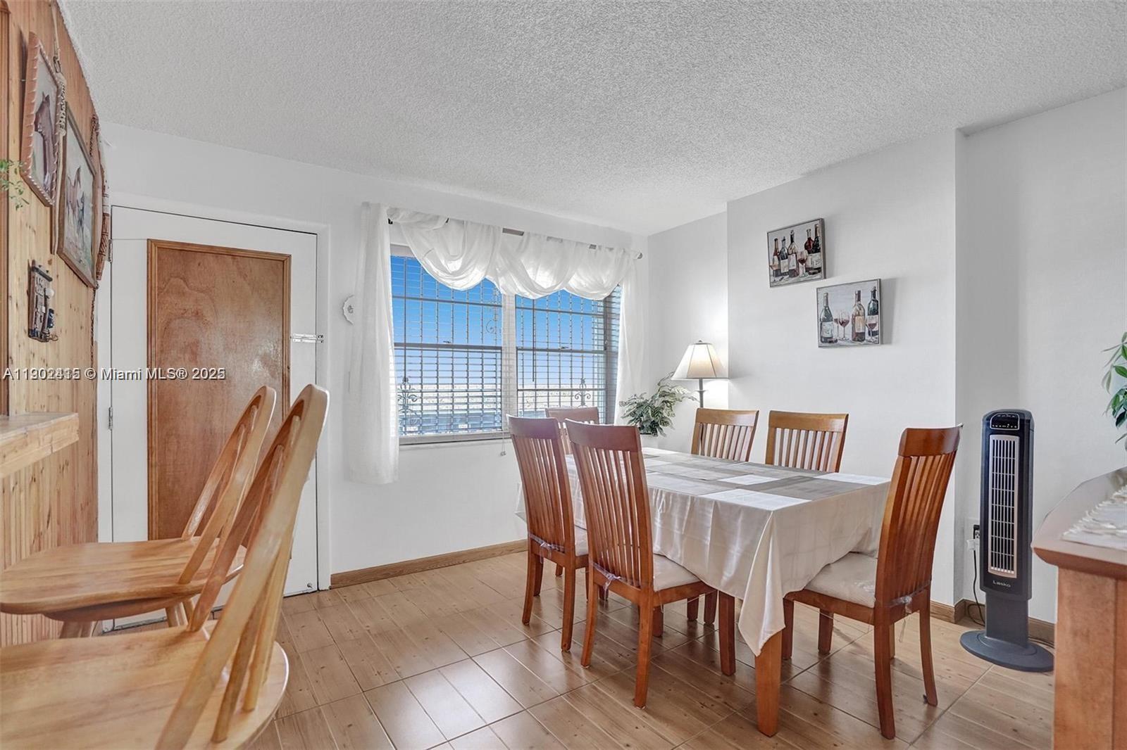 7620 Carlyle Avenue, Unit 703 Miami Beach, FL 33141 - Photo 11 of 46 a view of a dining room with furniture and a floor to ceiling window