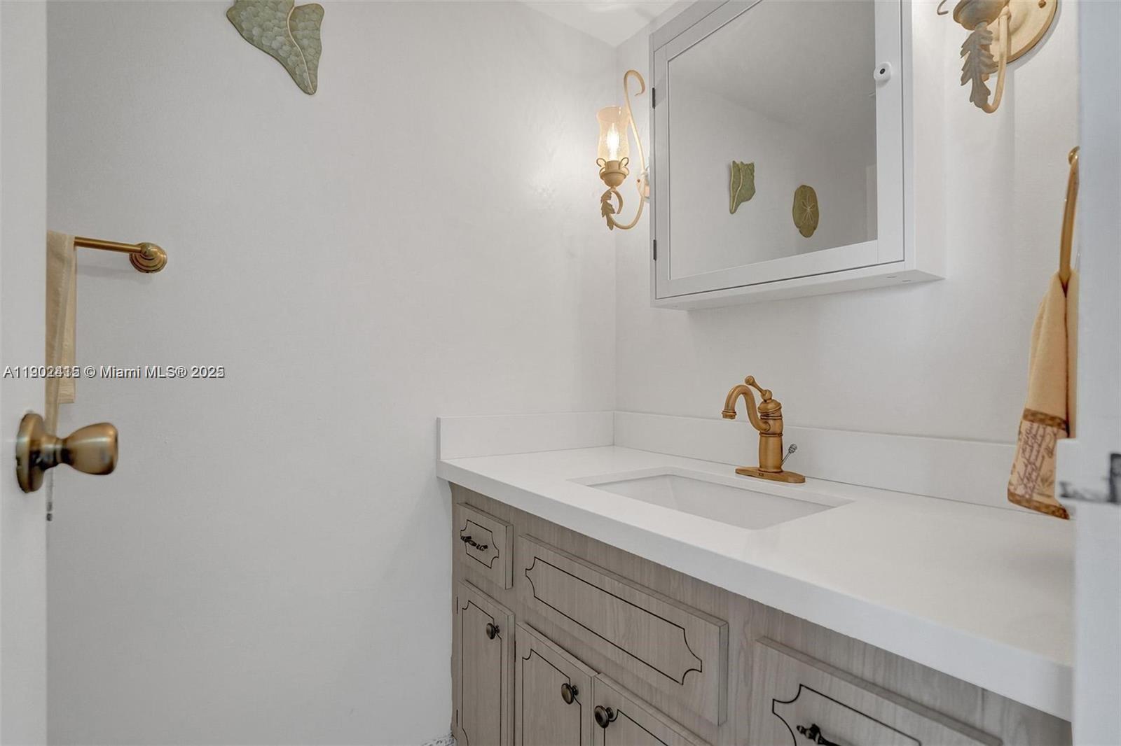 7620 Carlyle Avenue, Unit 703 Miami Beach, FL 33141 - Photo 16 of 46 a bathroom with a sink and a mirror