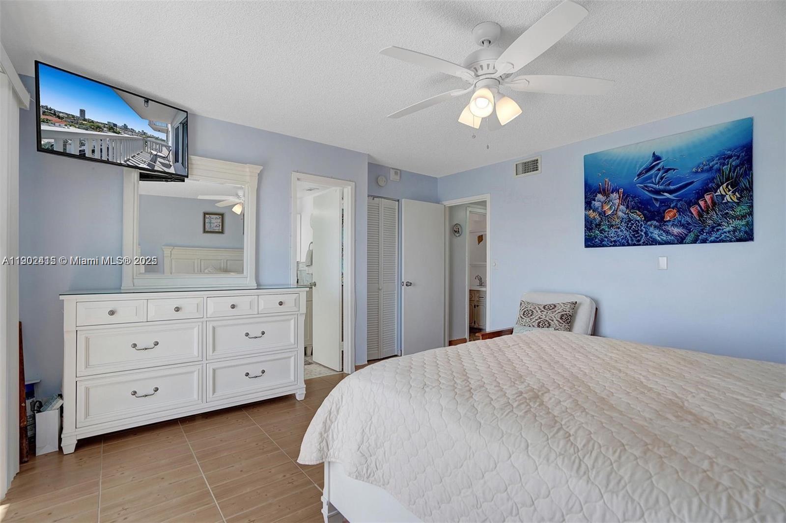 7620 Carlyle Avenue, Unit 703 Miami Beach, FL 33141 - Photo 19 of 46 a bedroom with a bed and a chandelier