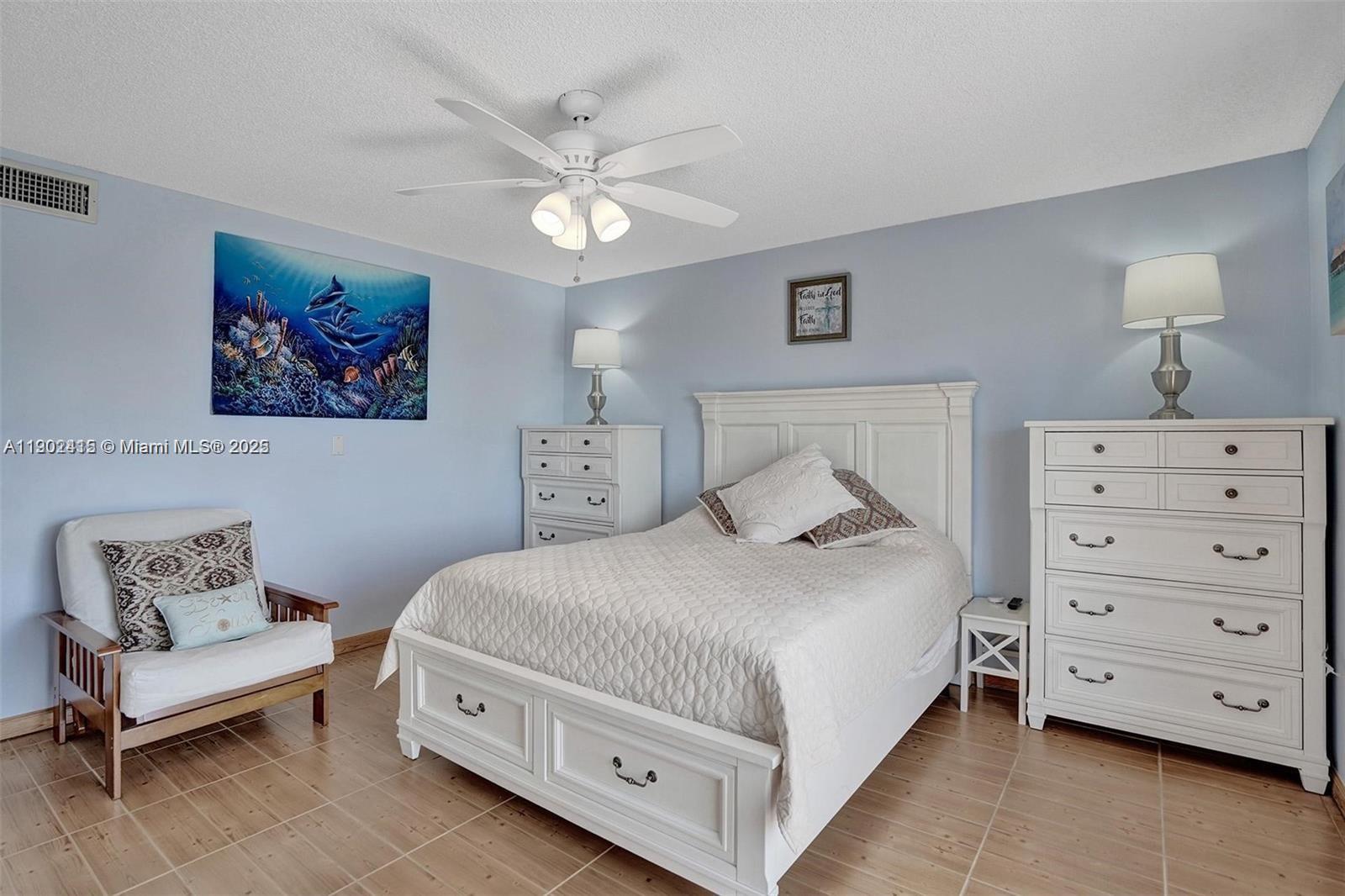 7620 Carlyle Avenue, Unit 703 Miami Beach, FL 33141 - Photo 21 of 46 a bedroom with a bed and a dresser